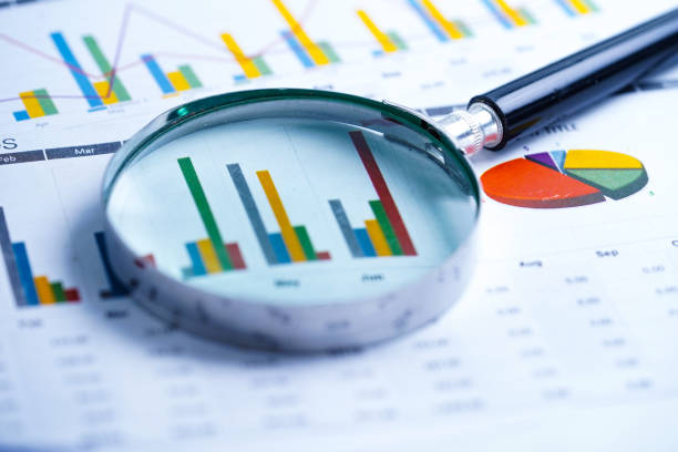 istock Magnifying glass on charts graphs spreadsheet paper. Financial development, Banking Account, Statistics, Investment Analytic research data economy, Stock exchange trading, Business office company meeting concept. 1144517273