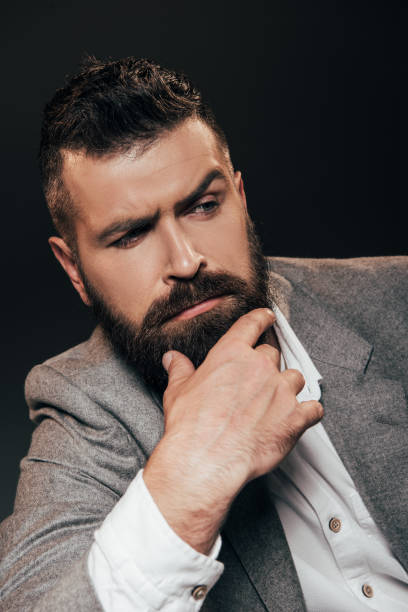 istock pensive beard businessman isolated on brown 1144518810
