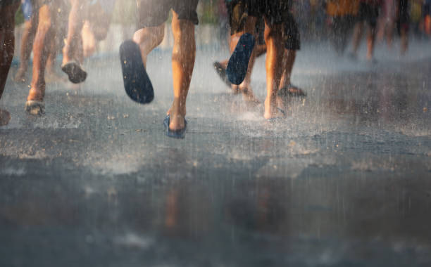 Asian children having fun to play with the rain. stock photo