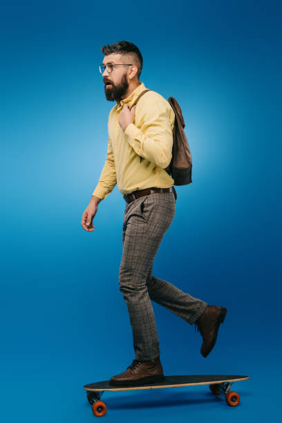 istock bearded man skateboarding in studio on blue 1144520306