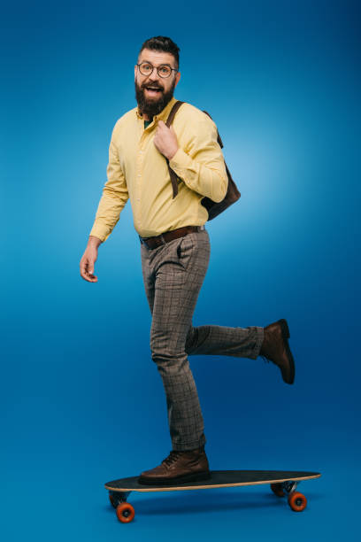 istock excited bearded man skateboarding in studio on blue 1144520307