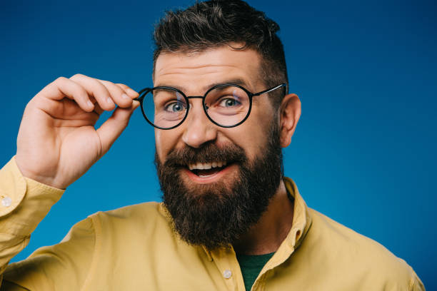 istock smiling bearded man in eyeglasses isolated on blue 1144520372