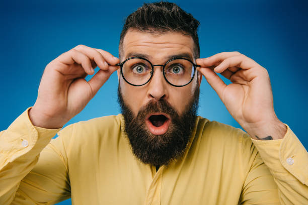 istock surprised bearded man in eyeglasses isolated on blue 1144521210