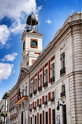 Beautiful perspective of the clock tower of the main square in Madrid called Puerta del Sol in a sunny day