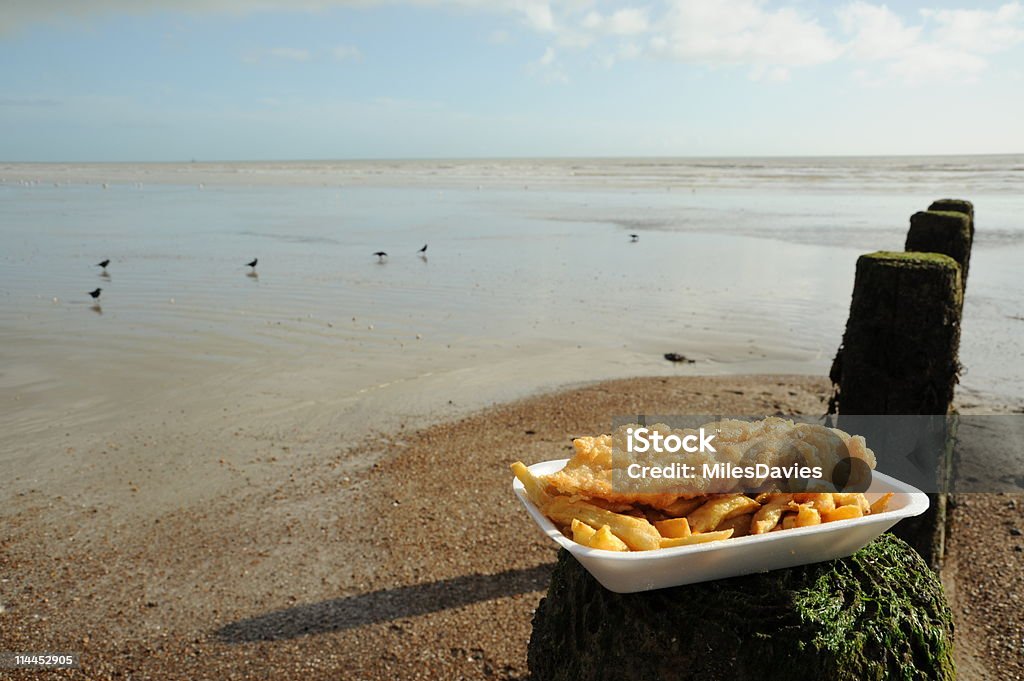 Fish and chips dish on a sea shore Photograph of fish and chips taken at the seaside Beach Stock Photo