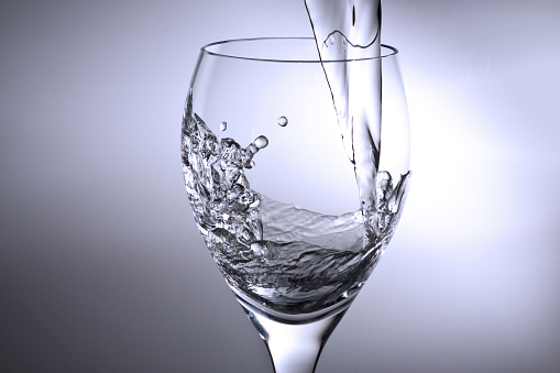Three glass glasses with different shapes filled with water with a white background