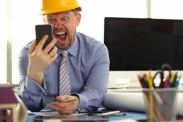 angry architect designer shout to phone in hand - protective workwear hat violence construction imagens e fotografias de stock