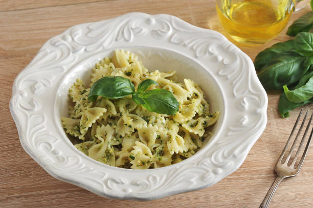 istock Pasta farfalle with pesto sauce in a white plate. 1144534187
