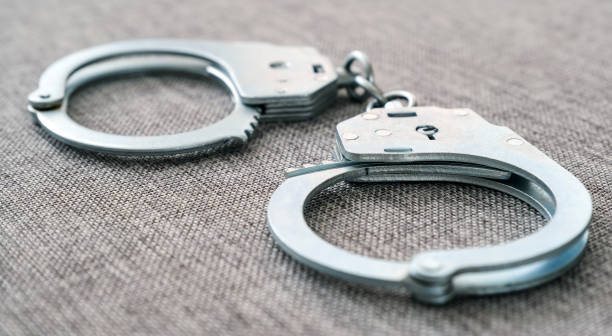 istock The cuffs on the table. Police unit. Close-up top view selective focus. 1144534264