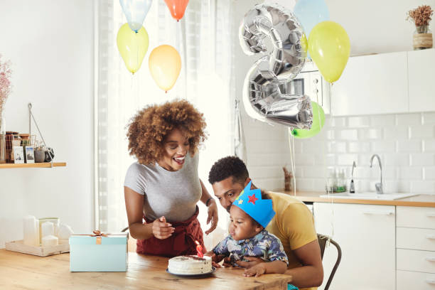 istock Parents looking at boy blowing birthday candles 1144534875
