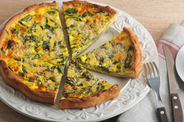 istock Open pie of quiche with spinach on a white plate. 1144536097