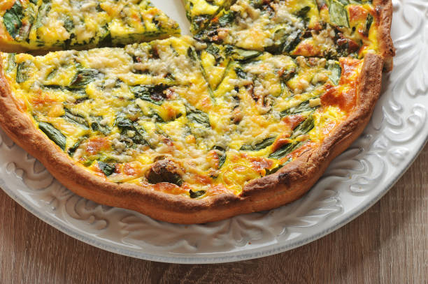 istock Open pie of quiche with spinach on a white plate. 1144536184