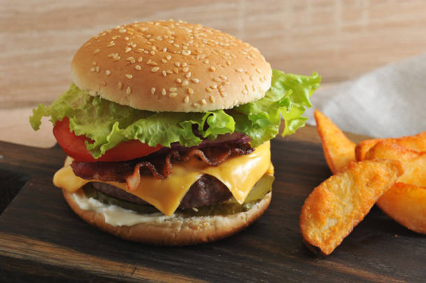 istock Appetizing cheeseburger and potatoes are rustic on a wooden board. 1144538300