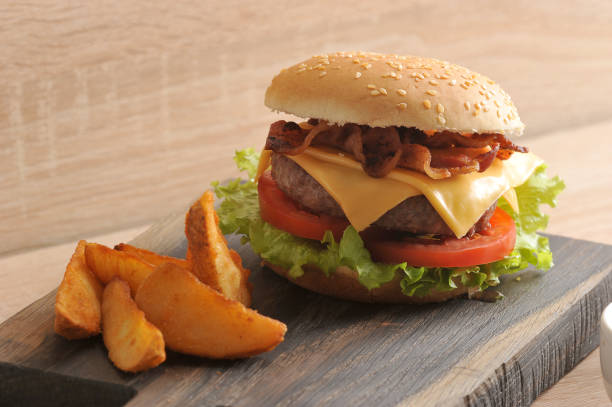 istock Hamburger and potatoes are rustic on a wooden board. 1144538422