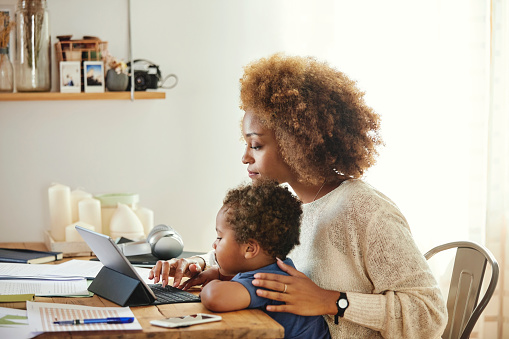 Madre con hijo trabajando en la tableta digital en casa photo