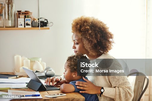istock Mother with son working on digital tablet at home 1144539387