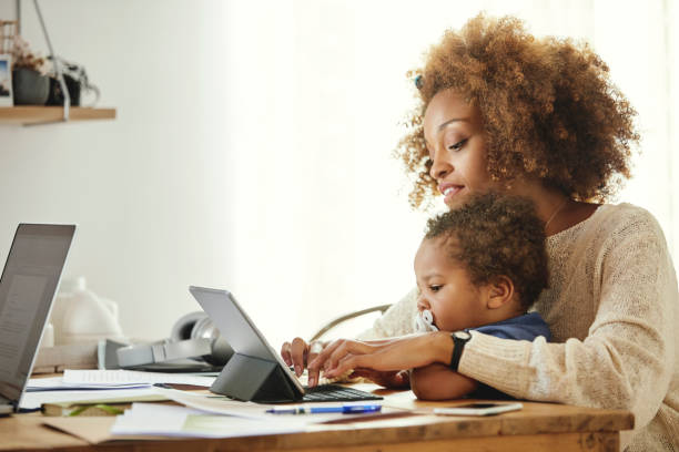 istock Mother with son typing on digital tablet at home 1144539403