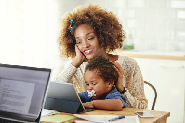 istock Woman looking at son with tablet computer at home 1144539453