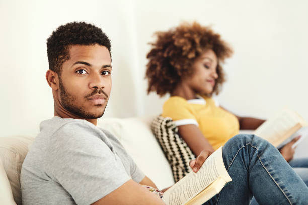istock Man reading book while sitting with woman 1144539753
