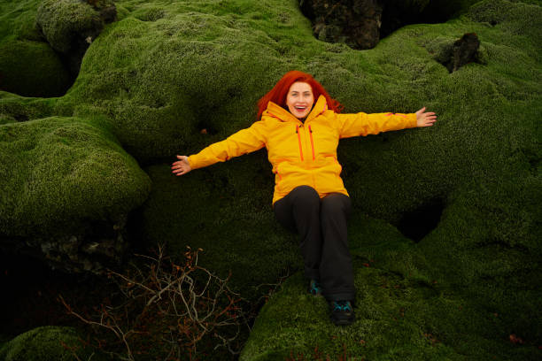 istock smiling woman posing on moss in Iceland 1144541102