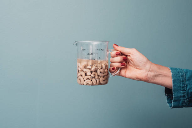 Woman holdin soaked cashew nuts Woman holdin soaked cashew nuts
Close up of measurements cup and cashew nuts in water drenched stock pictures, royalty-free photos & images