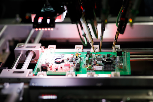 Printed circuit board assembly during a flying probe In-circuit test on flying probe tester system. Selective focus.
