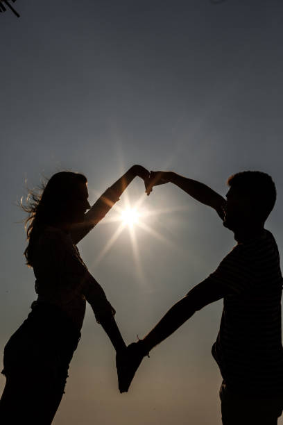 istock Couple making heart shape with arms during sunset 1144551507
