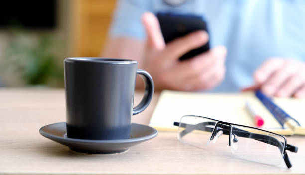 istock The man behind the Cup of coffee he reads a text. 1144551514