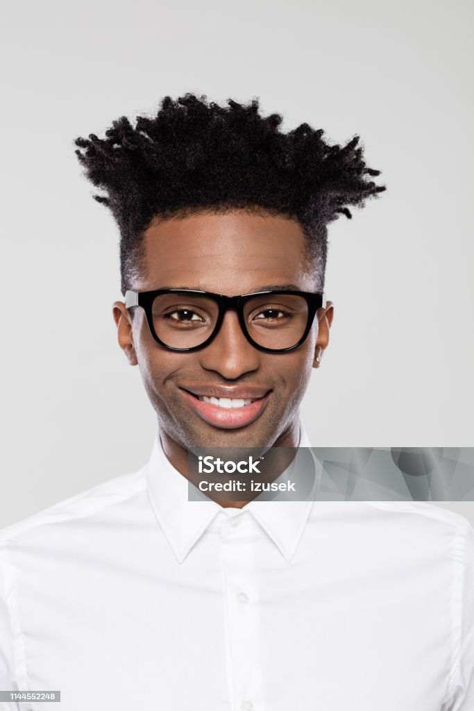 Happy young afro american businessman Close up portrait of happy young afro american businessman in nerd eyeglasses on gray background. Fashion Model Stock Photo