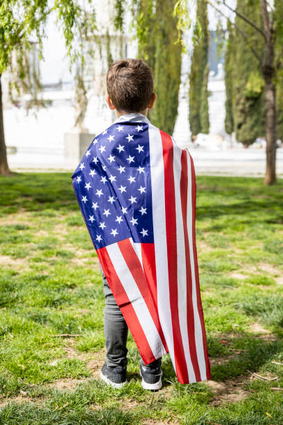 istock Little kid with the American flag on his back 1144553459