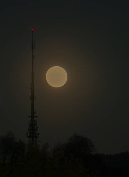 pleine lune se levant dans le ciel de nuit avec une antenne radio et une tour de transmission avec une lumière rouge de signalisation - full moon audio photos et images de collection