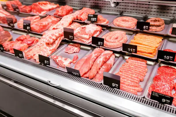 Various sorts of meat on display in shop or supermarket