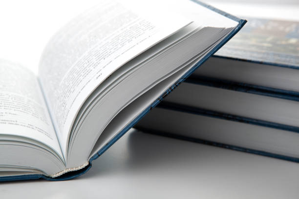 istock new open book with a stack of books on a gray table close up 1144559023