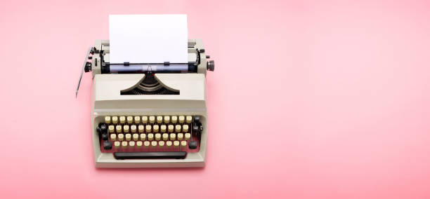 Typewriter from the 70s with blank paper on pink background. Top view of a typewriter from the 70s with blank paper for text, isolated on pink background. typewriter keyboard communication text office stock pictures, royalty-free photos & images