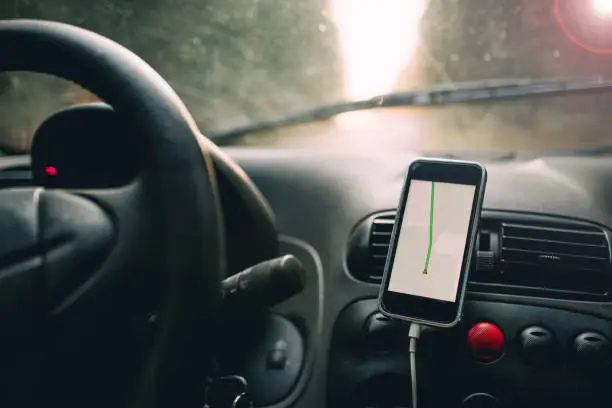 Photo of Navigator in the car's smartphone while traveling in the forest.