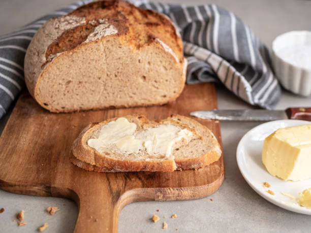 istock Bread loaf and a slice of bread with butter 1144562545