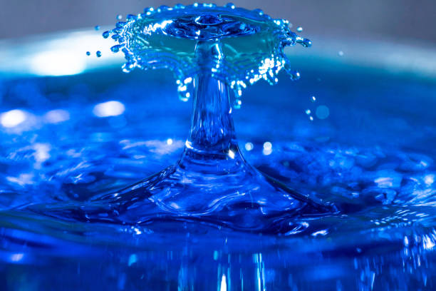 istock Close up of clear blue water drops colliding 1144564173