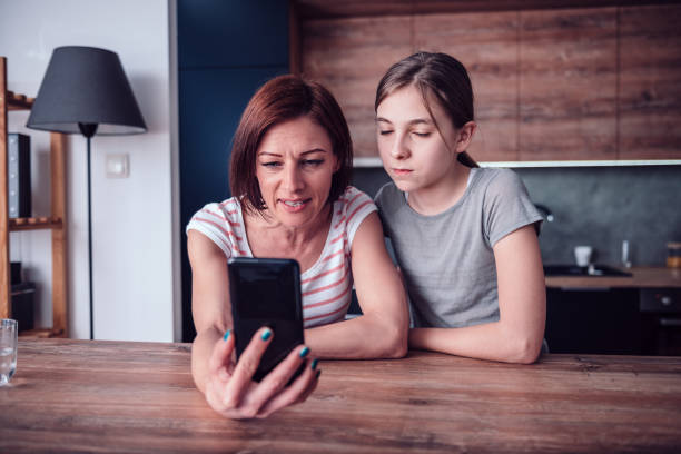 istock Mother and daughter having video call at home 1144565624