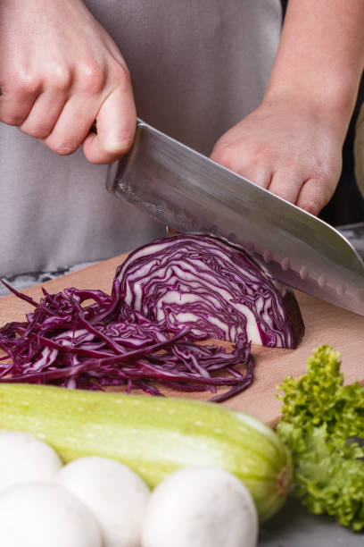 istock a young woman in a gray apron cuts red cabbage 1144566023