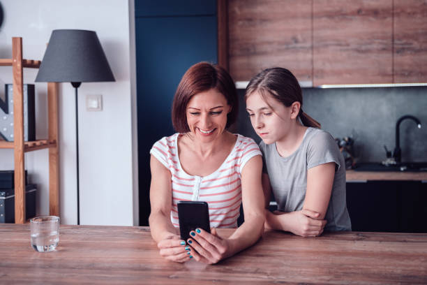 istock Mother and daughter using smart phone at home 1144566855