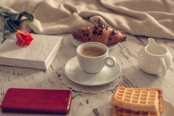 istock Coffee, waffles, smart phone and book on the table 1144566944