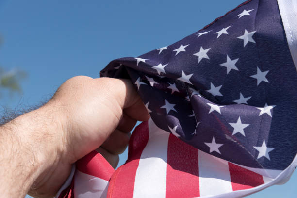 istock A man has the US flag in his hand 1144568768