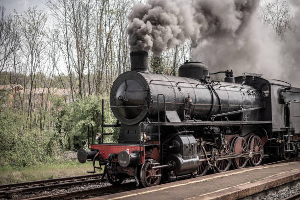 Steam train sorrounded by lots of smoke draws an passenger cabin, antique, sepia toned processed, wet plate and scratch processed,