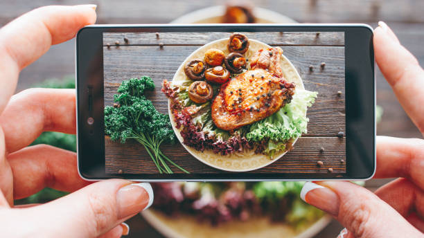 culinary blog home cooking hobby food recipe Culinary blog. Home cooking hobby. Food recipe. Closeup of female hands taking picture of roasted meat with grilled mushrooms. serving size photos stock pictures, royalty-free photos & images