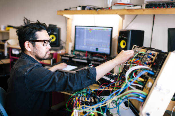 asiatischer mann macht analoge elektronische musik mit selbstgemachten instrumenten - toningenieur stock-fotos und bilder