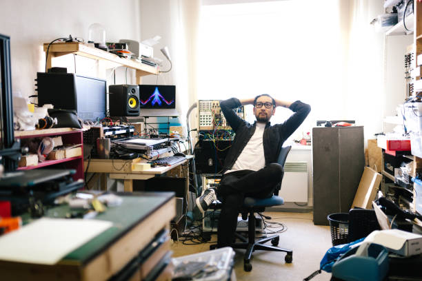 retrato de un productor de música electrónica contemplando - cluttered desk fotografías e imágenes de stock