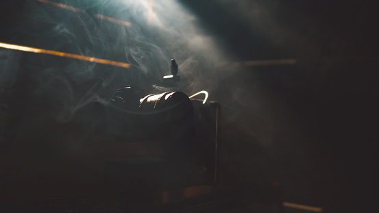 An epic photo of a camera in a barn full of smoke.