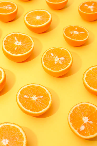 istock Orange juicy oranges split in half on yellow 1144574086
