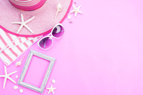 istock Beach accessories picture frame, sunglasses, starfish, beach hat and sea shell on pink background for summer holiday and vacation concept. 1144574431