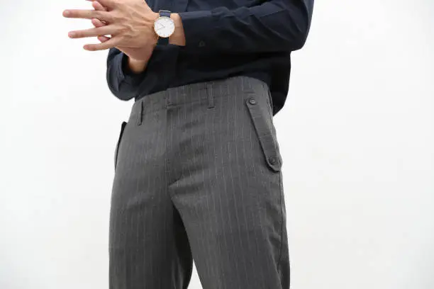 Photo of close-up of a handsome man in black formal shirt and gray long trousers.